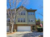 Charming three-story townhome featuring a stone facade and an attached two-car garage at 3699 Ashford Creek Ne Hl, Atlanta, GA 30319