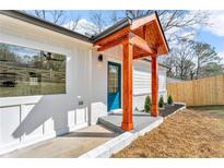 Welcoming front door with eye-catching wood pillar entryway detail and adjacent fenced in yard and attractive landscaping at 926 Natham Dr, Atlanta, GA 30315