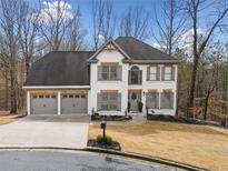 Charming two-story home featuring a three car garage, neutral colors, and mature landscaping at 327 Horseshoe Bnd, Woodstock, GA 30189