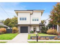 Contemporary two-story home featuring a stylish design, attached garage, and well-manicured lawn at 416 Glen Iris Ne Dr, Atlanta, GA 30308