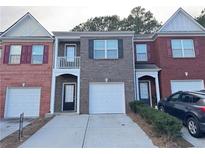 Three-unit brick facade townhomes feature individual garages and symmetrical window and door placement at 1530 Viero Dr, Lawrenceville, GA 30044