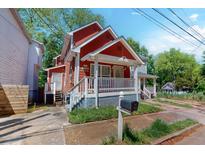 Charming red two-story home with a welcoming front porch and well-maintained yard at 945 Smith Sw St, Atlanta, GA 30310