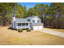 Charming two-story home featuring a covered porch, two-car garage, and beautifully landscaped front yard at 195 W Fork Way, Temple, GA 30179
