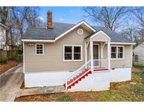 Charming home featuring a painted brick foundation, red stairs, and a quaint covered front porch at 2370 Mcafee Rd, Decatur, GA 30032