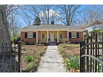 Charming brick home featuring a manicured front yard, walkway, and a welcoming covered porch with columns at 245 S Columbia Dr, Decatur, GA 30030