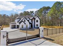 Striking two-story home with black trim, gated driveway, and an attached three car garage at 3057 Bold Springs Rd, Dacula, GA 30019