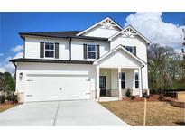 Charming two-story home featuring white siding, black shutters, and a spacious two-car garage at 660 Redhead Way (Lot 24), Grayson, GA 30017
