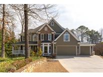 Charming two-story home with a stone and siding exterior, three-car garage and well-manicured landscaping at 764 Sharpshooters Nw Rdg, Marietta, GA 30064