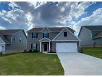 Two-story home with gray siding, brick accents, well-manicured lawn, and a two-car garage at 117 Oliver Dr, Locust Grove, GA 30248