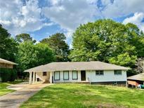 Charming single-story home with fresh white paint, large windows, and a well-maintained front lawn at 4222 Castle Pines Ct, Tucker, GA 30084