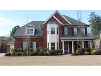 Beautiful two-story brick home with a manicured lawn and a welcoming front porch at 2480 Copper Mill Trl, Cumming, GA 30041