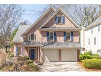 Charming two-story brick home with a two-car garage, blue shutters, and a well-manicured lawn at 4162 Gateswalk Se Dr, Smyrna, GA 30080