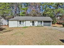 Charming single story home with a gray roof, a dark garage door, and white brick walls at 3915 Basil Sw Way, Atlanta, GA 30331