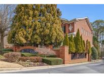 A stately brick Kingston Gate entrance framed by mature landscaping and manicured greenery at 4298 Kingston Gate Cv, Chamblee, GA 30341