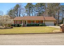 Charming single-story brick home with a well-manicured lawn, mature trees, and a welcoming front porch at 4791 Wyndale Cir Se, Conyers, GA 30094