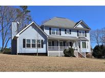 Charming two-story home with light blue siding, black shutters and a welcoming front porch at 4905 Puritan Dr, Sugar Hill, GA 30518