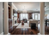 Bright living room featuring a fireplace, beautiful hardwood floors, large windows, and elegant lighting at 3280 Stillhouse Se Ln # 101, Atlanta, GA 30339