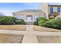 Charming home with a well-manicured front yard and a stately entrance featuring an arched doorway at 9390 Knollcrest, Alpharetta, GA 30022