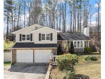 Charming two-story home featuring a two-car garage and lovely landscaping with trees and flowers at 1157 Richland Trce, Sugar Hill, GA 30518