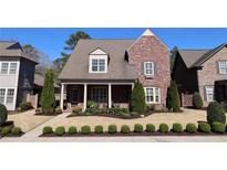 Charming brick home with manicured lawn and lush landscaping creates inviting curb appeal at 184 Cadence Trl, Canton, GA 30115