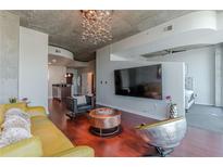 Stylish living room with modern chandelier, hardwood floors, and large screen TV at 400 W Peachtree Nw St # 3412, Atlanta, GA 30308