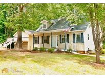 Charming home featuring a cozy front porch and a detached garage with upper level deck at 410 Invector Ct, Locust Grove, GA 30248