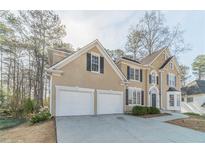 Charming two-story home with neutral stucco, black shutters, white trim, and a spacious two-car garage at 1351 Mckendree Park Ct, Lawrenceville, GA 30043