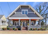 Charming gray two-story home with inviting front porch and manicured landscaping at 1402 Belmont Sw Ave, Atlanta, GA 30310