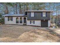 Charming two-story home featuring brick and wood with an attached garage at 6615 Buckhurst Trl, Atlanta, GA 30349