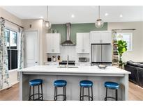 A contemporary kitchen features white cabinets, stainless steel appliances, an island with seating, and pendant lighting at 723 Perch Pl, Atlanta, GA 30312