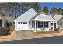 Charming home featuring a covered front porch and an attached one car garage at 126 Rose Cottage Ln, Woodstock, GA 30189