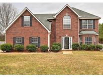 Charming two-story brick home featuring a manicured front lawn and traditional architectural details at 4871 Ship Jack Ln, Decatur, GA 30035
