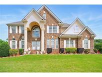 Stately two-story brick home with well-manicured lawn and symmetrical landscaping at 8056 Revere Dr, Mcdonough, GA 30252