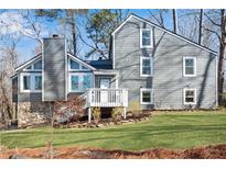 Charming gray two-story home featuring a well-maintained lawn and a stone accent wall at 2421 Spring Lake Dr, Marietta, GA 30062