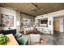 Open-concept living room featuring stylish decor, concrete ceilings, and an eat-in kitchen bar at 245 N Highland Ne Ave # 210, Atlanta, GA 30307