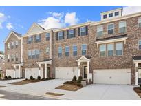 New townhomes with brick exteriors, private garages, and professionally landscaped front yards at 3186 Eastham Run Dr, Dacula, GA 30019