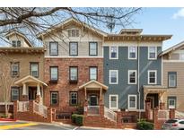 Three-story townhome with brick and siding, featuring covered entrances and well-maintained landscaping at 655 Mead Se St # 59, Atlanta, GA 30312