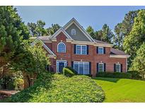 Beautiful brick two-story home with manicured lawn and mature trees at 2088 Hedgewood Trce, Lawrenceville, GA 30043