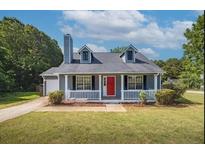 Charming single-story home featuring a manicured lawn and a bright red front door at 1743 Wee Kirk Se Rd, Atlanta, GA 30316