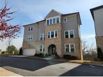 Beautiful three-story townhome with attached garage and manicured landscaping at 3794 Allegretto Cir, Atlanta, GA 30339