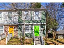 Charming townhome featuring a bright green front door and manicured front yard at 845 Regal Path Ln, Decatur, GA 30030