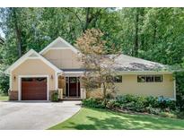 Charming single-story home featuring a well-manicured lawn and mature trees at 1233 Poplar Grove Ne Dr, Atlanta, GA 30306