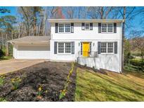 Charming two-story home with a well-manicured lawn, painted brick, and an inviting yellow front door at 4620 Central Dr, Stone Mountain, GA 30083