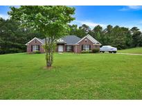 Charming one-story brick home features a spacious front yard, black shutters, and a welcoming entrance at 501 Barhams Ridge Dr, Mcdonough, GA 30252