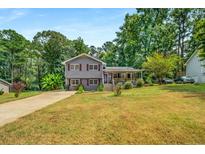 Charming split-level home with a cozy front porch and well-maintained landscaping at 3989 Woodland Se Cir, Conyers, GA 30013