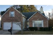 Charming brick two-story home with an attached two-car garage and a well-maintained front yard at 1956 Cutters Mill Way, Lithonia, GA 30058