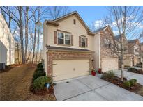 Charming two-story townhouse featuring a brick facade, two-car garage, and well-maintained landscaping at 2515 Norwood Park Xing, Atlanta, GA 30340