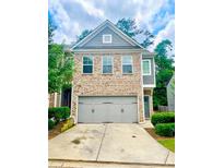 Charming brick townhome featuring a spacious two-car garage and well-manicured landscaping at 4353 Morning Vw, Stone Mountain, GA 30083