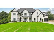 Stunning white two-story home with a manicured lawn, black trim, and a dark grey roof on a sunny day at 3735 Hamilton Mill Rd, Buford, GA 30519