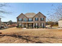 Traditional brick home featuring a manicured front lawn and mature landscaping at 141 Aylesbury Blvd, Mcdonough, GA 30252